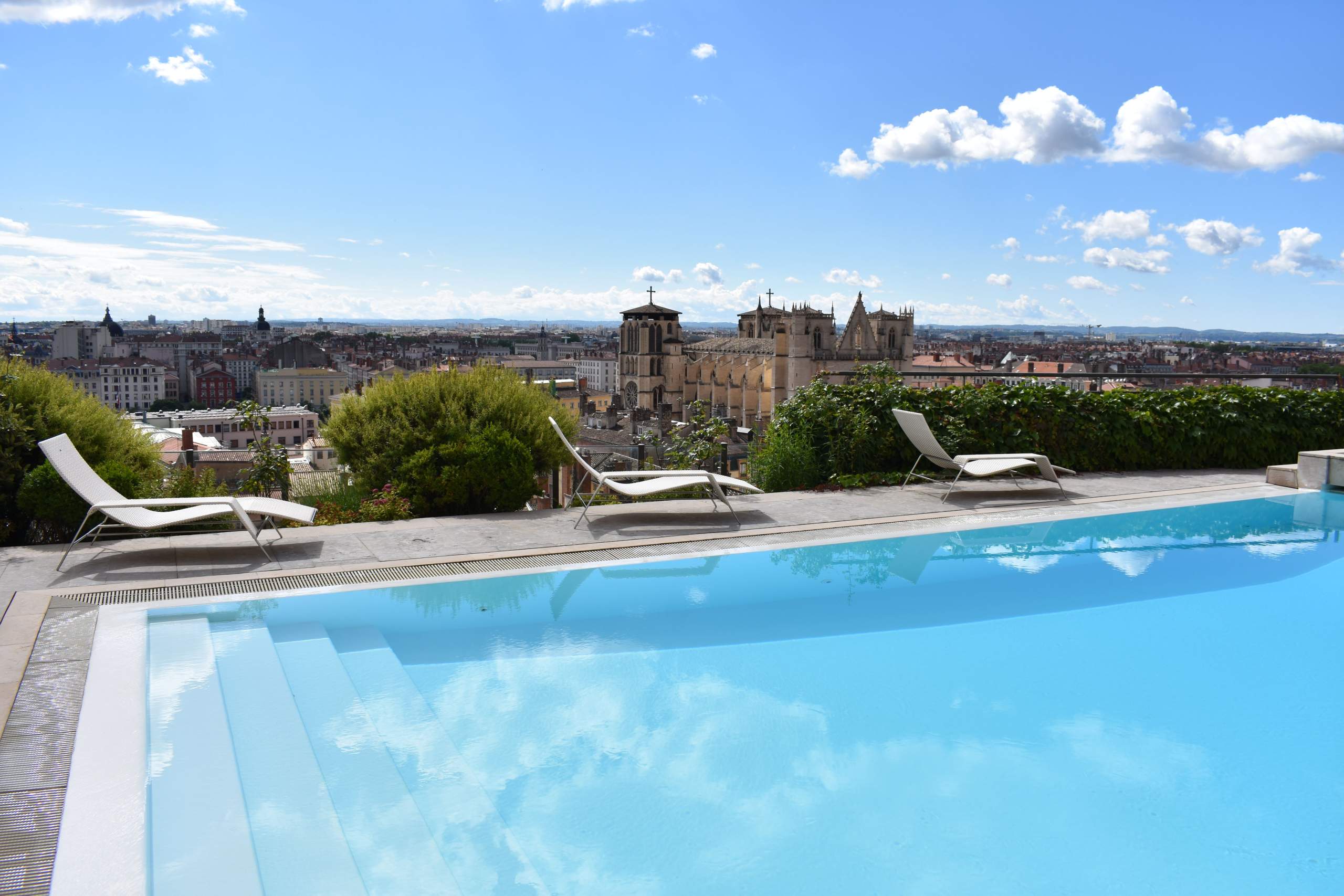 Outdoor swimming pool at La Villa Florentine with a view of Lyon